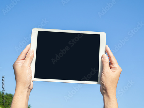 finger touching screen with blue backgroun, isolated on blue sky