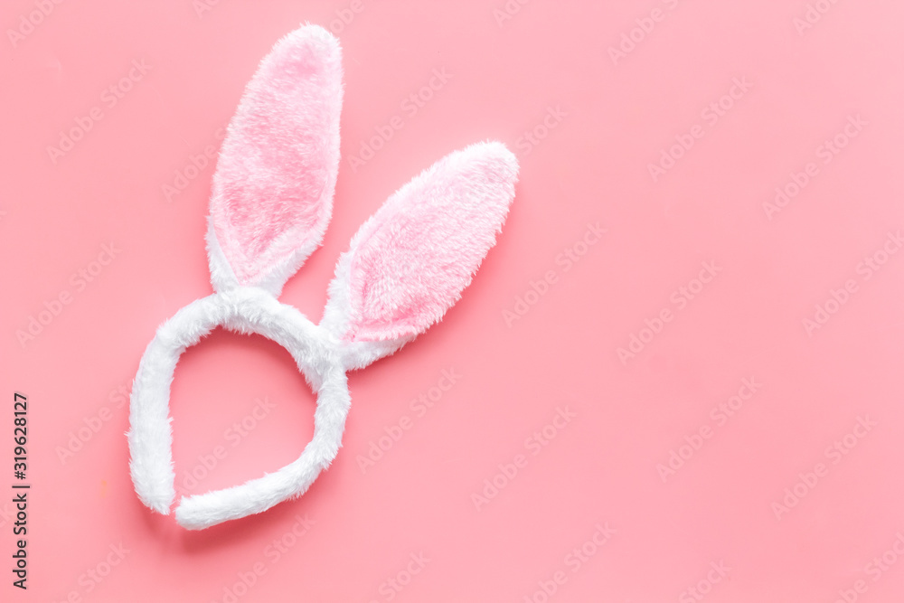 Easter bunny concept. Toy rabbit's ears for head on pink background top-down copy space Easter bunny concept. Toy rabbit's ears for head on pink background top-down copy space