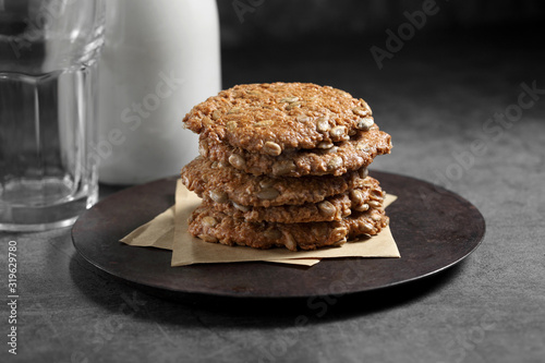 Chocolate and sunflower seed cookies with milk in glass bottle, Cookies and milk on rustic background
