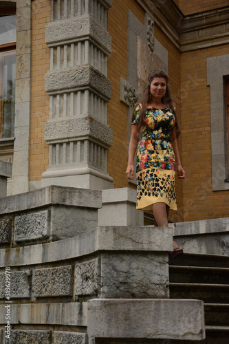 Crimea, Russia, Massandra castle. A beautiful young woman in elegant dress. The Princess has a cute dress with a pattern of flowers. The background of the Palace, the garden, the sky. © Nadezhda Taran