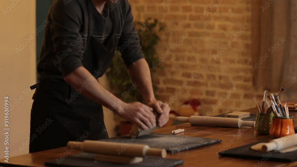 A man kneads clay in a pottery workshop. Male hands closeup knead clay. Clay modeling workshop. A man kneads clay in a pottery workshop. Male hands closeup knead clay. Clay modeling workshop.