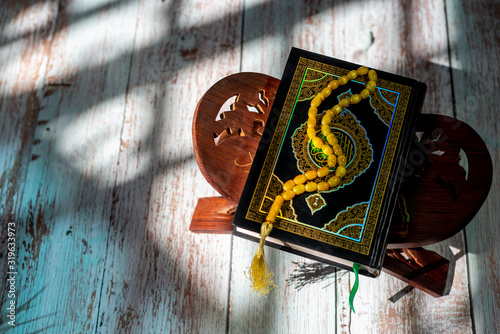 Holy Quran on a wooden table. Ramadan is coming. Shallow depth of field. Shadow and light