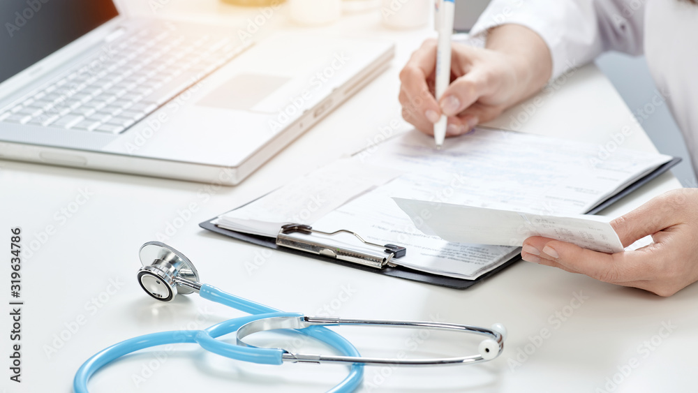 doctor in his office and writing out a prescription. doctor in his office and writing out a prescription.