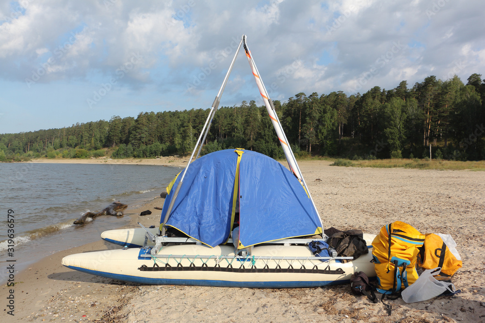 Sailing catamaran with a tent on the shore of the Ob Reservoir, Novosibirsk, Russia Sailing catamaran with a tent on the shore of the Ob Reservoir, Novosibirsk, Russia