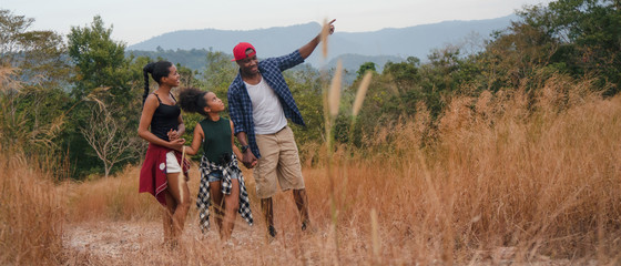african american family having fun traveling and camping together in natural forest and park
