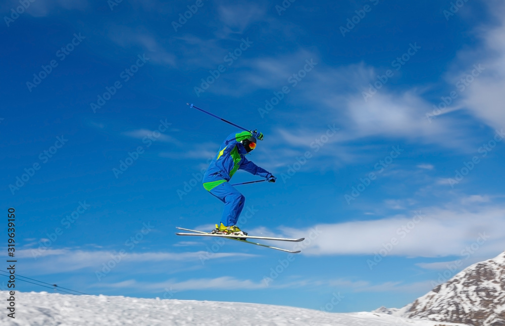 Male skier jumps in snow park against the blue sky. Livigno, Italy