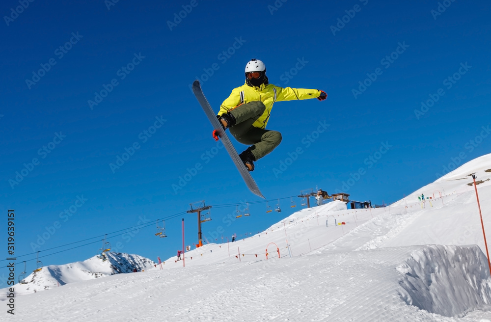 Male snowboarder against the blue sky. Livigno, Italy