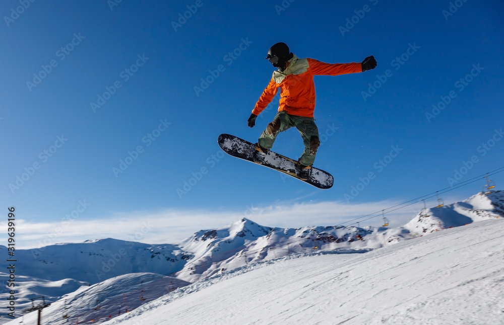 Snowboarder jumps in snow park in the snowy mountains  in Livigno, Italy