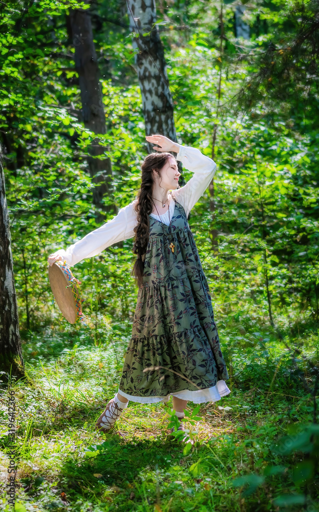 girl witch performs a ritual dance with a tambourine