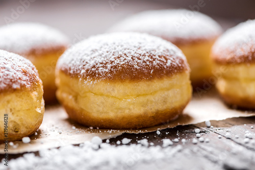 Foto Close-up of donuts (Berlin pancakes) dusted with powdered sugar served on a rust