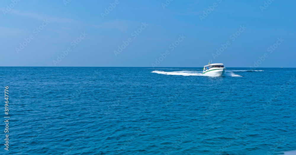 - White ship sails on blue sea, on waves in tropics, summer