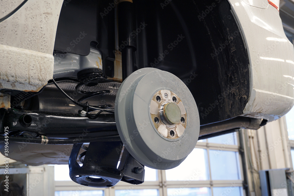 The car on the service is lifted on a lift, the wheel is removed from the car. Rear brake drum and rear suspension.