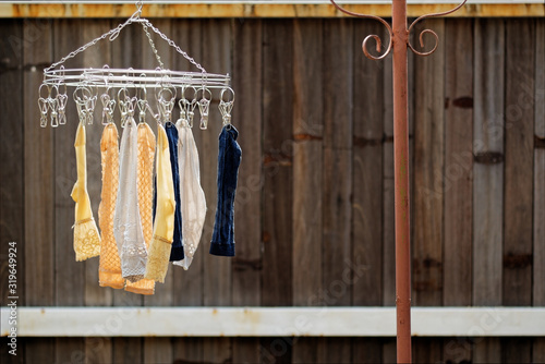 Clothes line dry socks with clothes Wire and sunlight at noon. Brown wood background. Copyspace on the right.