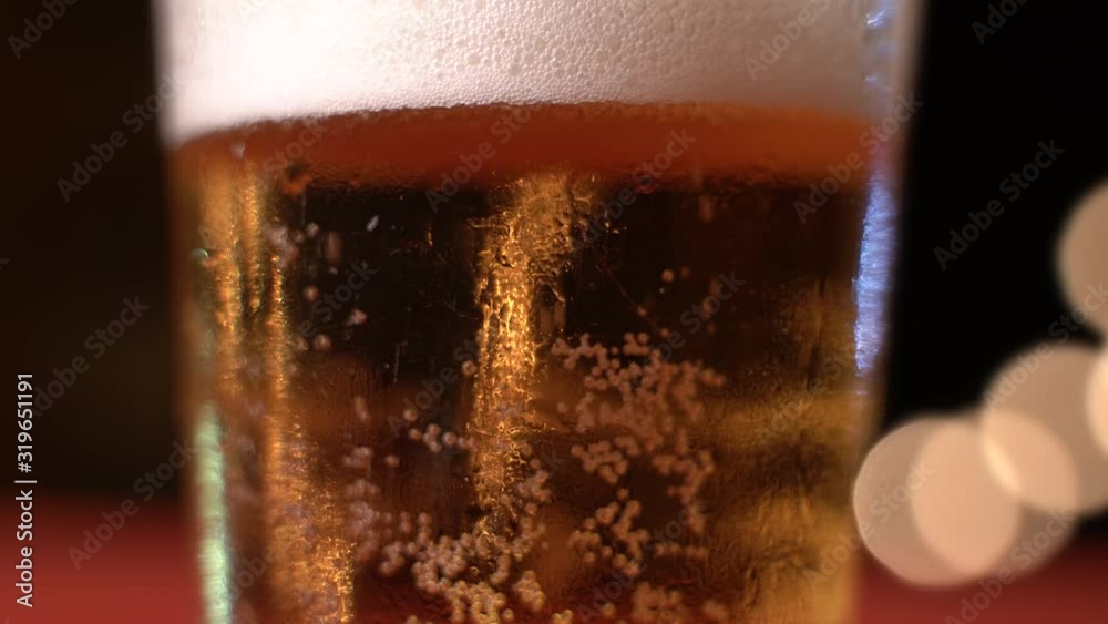 Cold foamy beer in a rotating glass