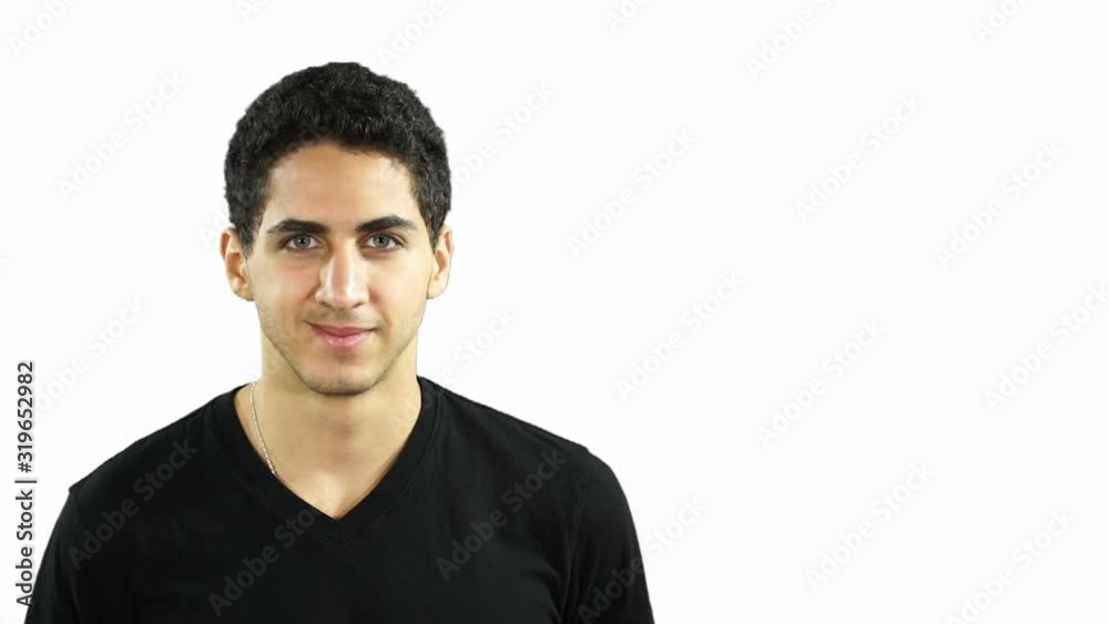 Young Middle Eastern man Looking at the camera - He is smiling with a White Background - Copyspace - Stock Video Clip Footage Young Middle Eastern man Looking at the camera - He is smiling with a White Background - Copyspace - Stock Video Clip Footage