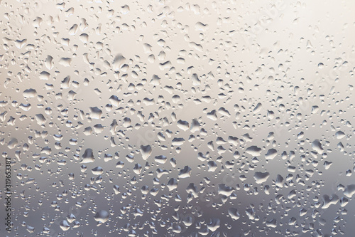 Raindrops on muddy window pane