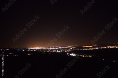 vista de una ciudad de noche desde lo alto de un monte