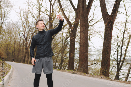 Healthy life. Athletic man in sportswear make selfie. Outdoor workout. Fitness app. Ui ux concept. Gadget in modern sport. Sport app on phone. Digital sport. Smart watch. © Олександр Цимбалюк