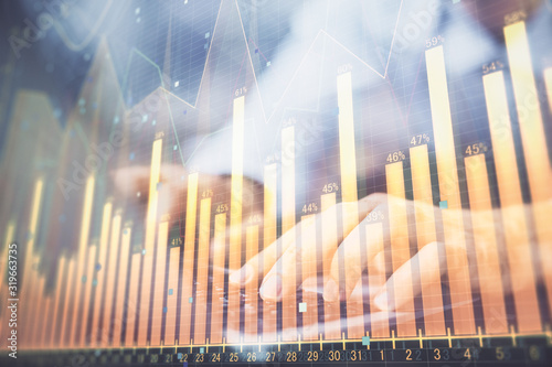 Forex graph with businessman typing on computer in office on background. Concept of analysis. Double exposure.