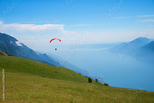 Monte Baldo mountain italy, paraglider floating over lake garda.