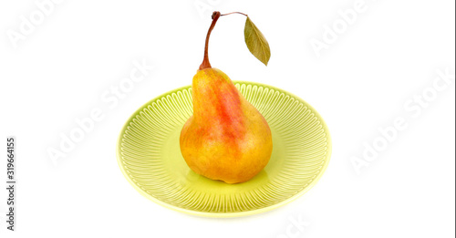 Big ripe yellow pear on a ceramic plate isolated on white background