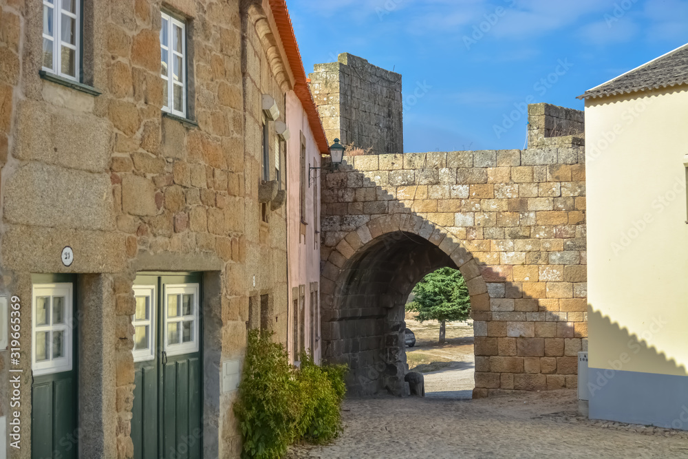 View at exterior fortress gate and the medieval village inside fortress castle of Castelo Mendo medieval buildings