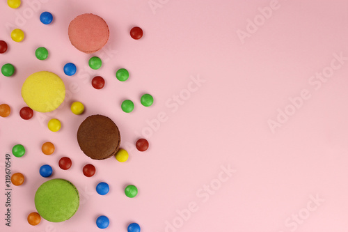 Colored macaroons or macarons on a pink background, copy space for your text