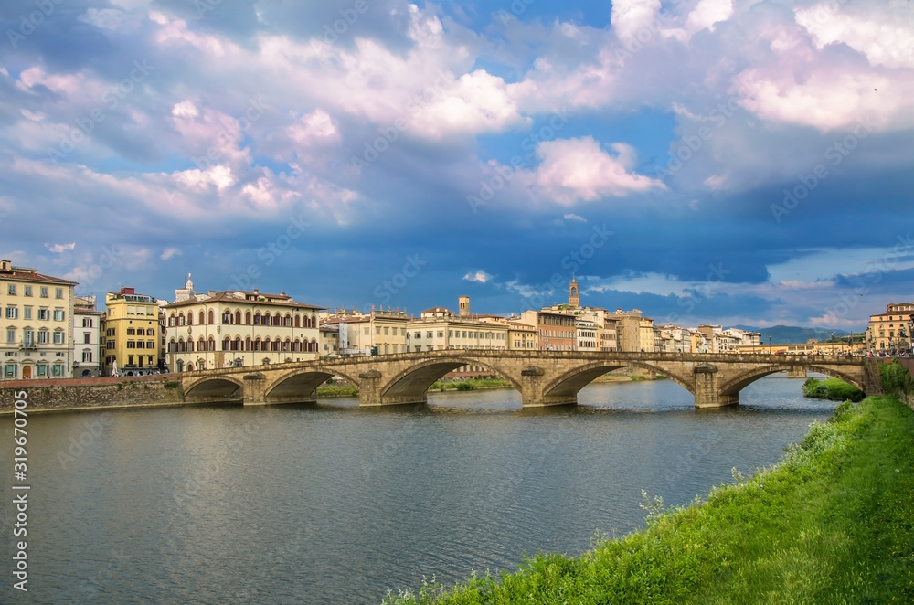 View of bridge in Florence during sunset - Ponte alla Carraia,  five-arched bridge over Arno River in the Tuscany region of Italy. Beautiful blue with pink sky with clouds. 