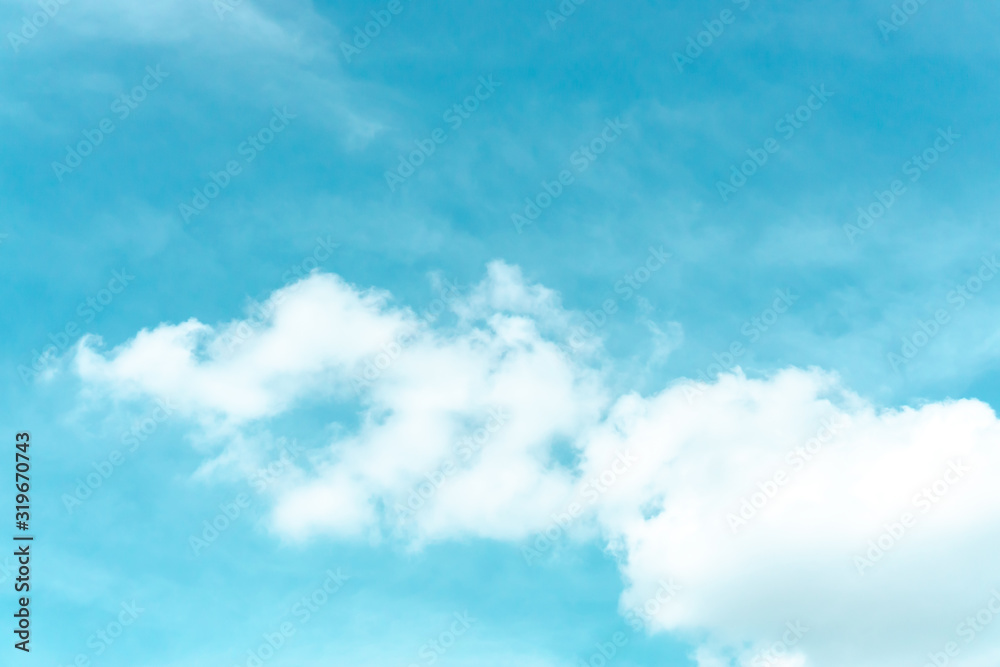 white fluffy clouds and blue pastel sky in a sunny day
