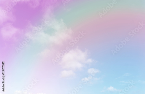 Beautiful pastel color with rainbow shade on white fluffy clouds, colorful blue sky on background, upward view and copy space image