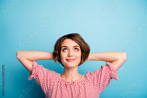 Closeup photo of attractive funny lady hold hands behind head look up empty space dreamer enjoy vacation time wear casual white red blouse isolated blue color background