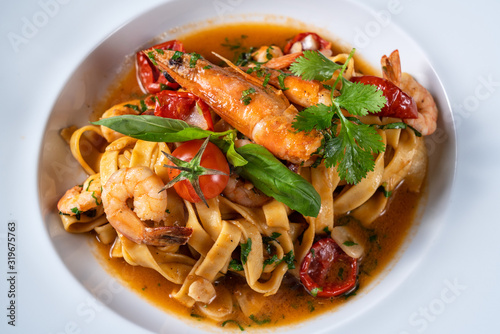 Italian pasta dish with shrimp stewed in sauce. Close from above.
