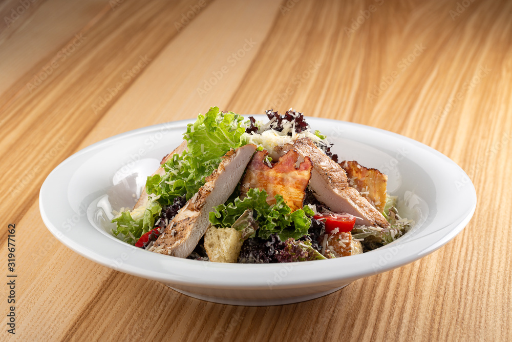 Delicious fresh salad. Caesar salad. Caesar salad with fresh lettuce, parmesan, fried croutons, chicken. Restaurant food, close up. Meat salad. Close up view. Delicious fresh salad. Caesar salad. Caesar salad with fresh lettuce, parmesan, fried croutons, chicken. Restaurant food, close up. Meat salad. Close up view.
