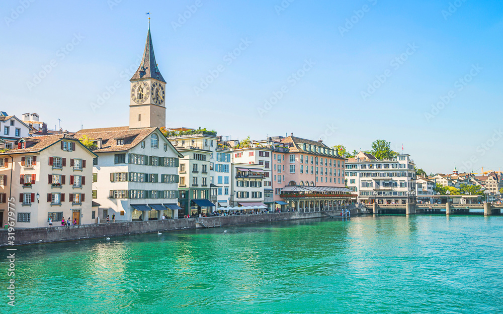 Zurich city center and Limmat quay in summer with Cathedral and city hall clock towers spires in summertime