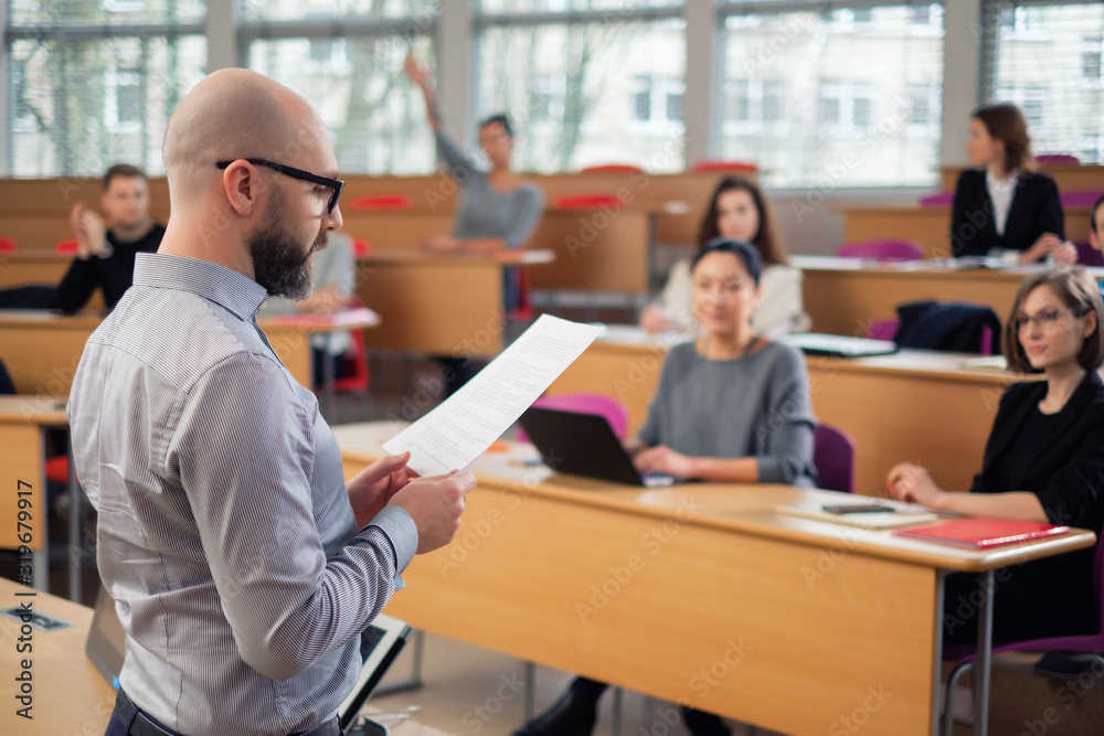 Lecturer and multinational group of students in an auditorium Lecturer and multinational group of students in an auditorium