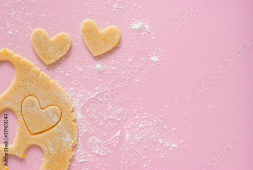 Wallpaper Mural Cutting out heart-shaped cookies from flour-flavored dough on a light pink surface. Top view, the process of preparing homemade treats for Valentine's Day. Torontodigital.ca