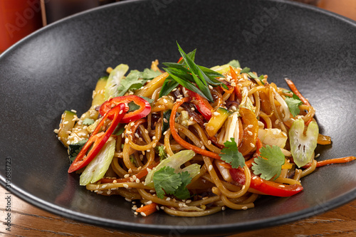 Stir fry with soba noodles, vegetables. Asian healthy food, stir fried meal in bowls. Spicy noodles. Vegetarian Noodles or Vegetable Hakka Noodles or Chow Mein. Indo-chinese cuisine hot dish