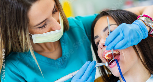 Young woman having dental check up at dentist office  showing perfect straight white teeth.