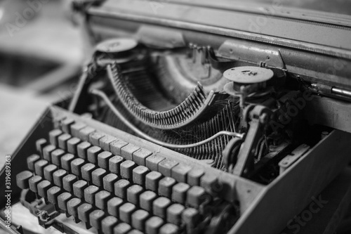 Black and white photo. Old, antique typewriter close-up in the dust.
