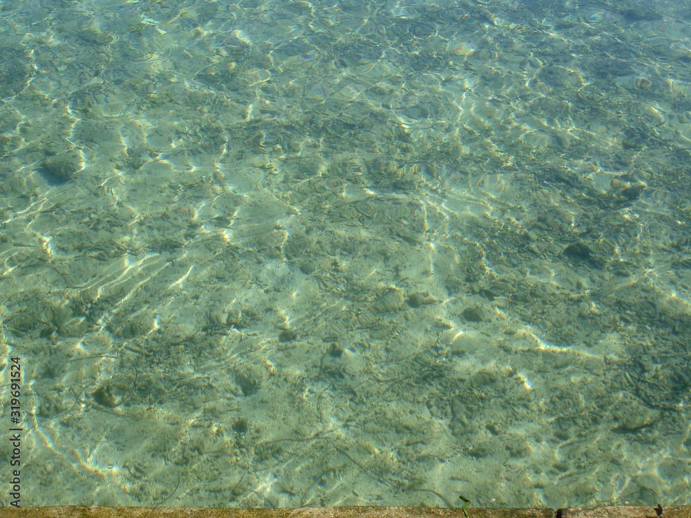 Fototapeta premium Clear transparent waters of a beach with the bottom from the surface