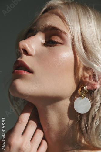 Fashion beauty portrait of young beautiful woman wearing earrings.