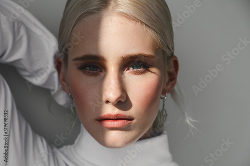 Fashion beauty portrait of young beautiful woman with shadow on her face