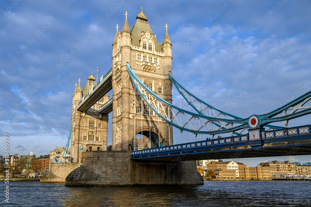 Tower Bridge in the City of London, UK. Tower Bridge crosses the River Thames and is one of the most famous tourist sights in London. Landscape view of Tower Bridge in late afternoon light.