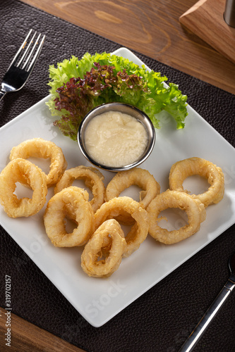 delicious golden battered, breaded and deep fried crispy onion rings. Fast food products photo