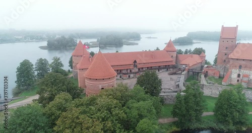 Trakai, Lithuania: medieval gothic Island castle, located in Galve lake and town in the background. Aerial above summer UAV top view, flat lay of the most beautiful Lithuanian landmark. photo