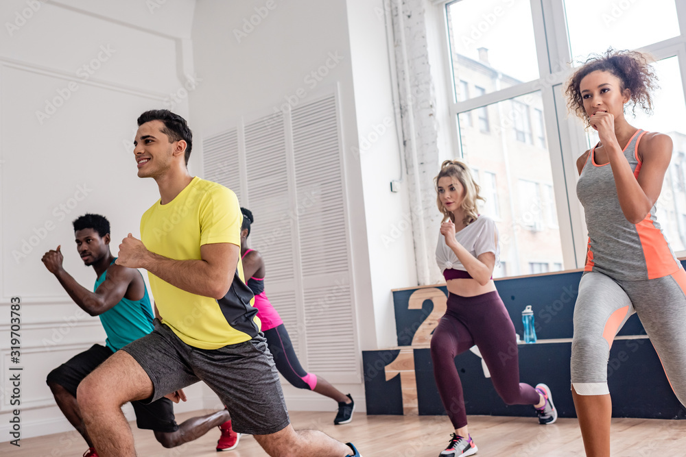 Smiling multiethnic dancers performing zumba in dance studio