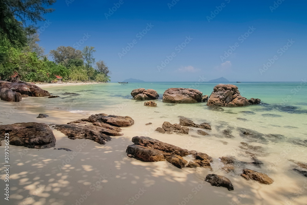 view seaside of many arch rocks on white sand beach with blue-green sea and blue sky background, Ko Bulon Le island, Satun province, southern of Thailand.