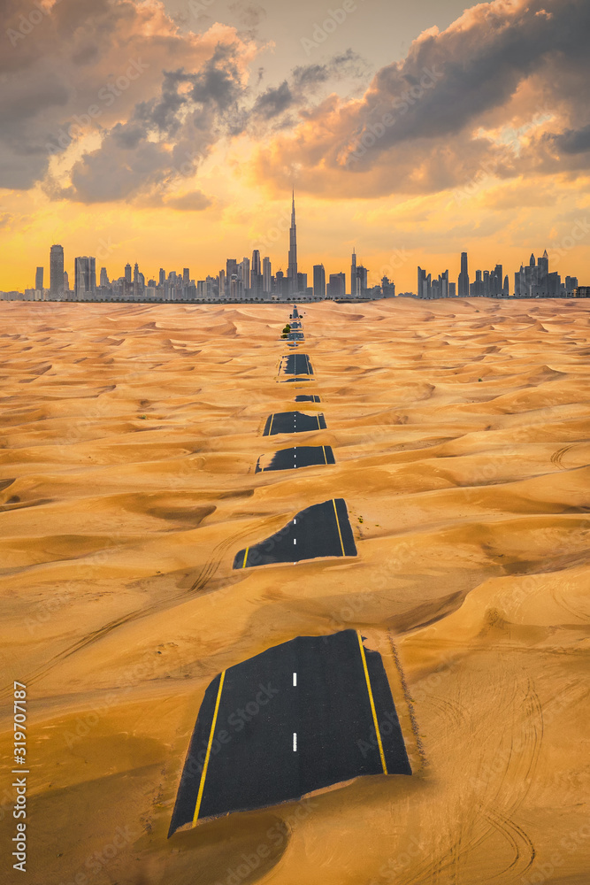 Aerial view of Dubai Downtown skyline with half desert sand road