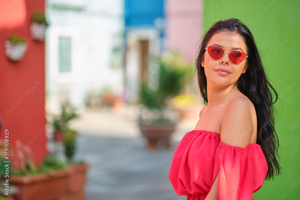 traveler woman posing among colorful houses on Burano island, Venice. Tourism in Italy concept