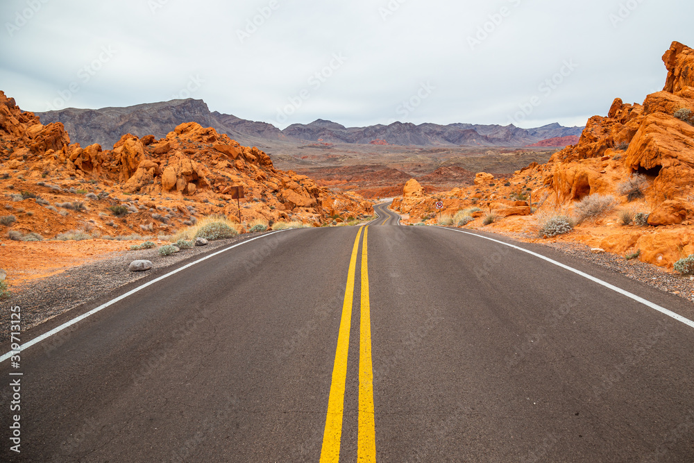 Desert road with red rocky landscape in Valley of Fire State Park, USA